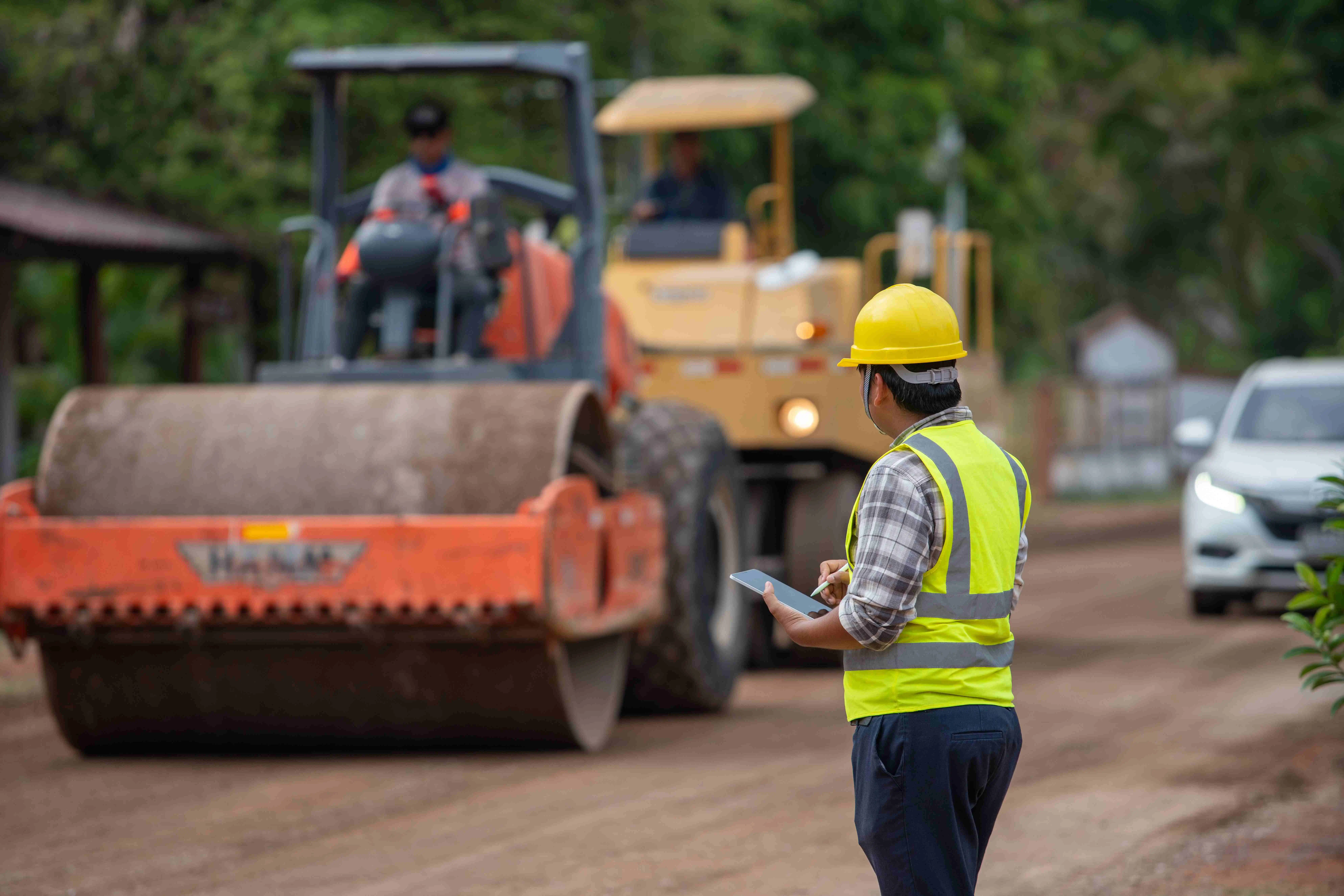Worker supervising roadrollers